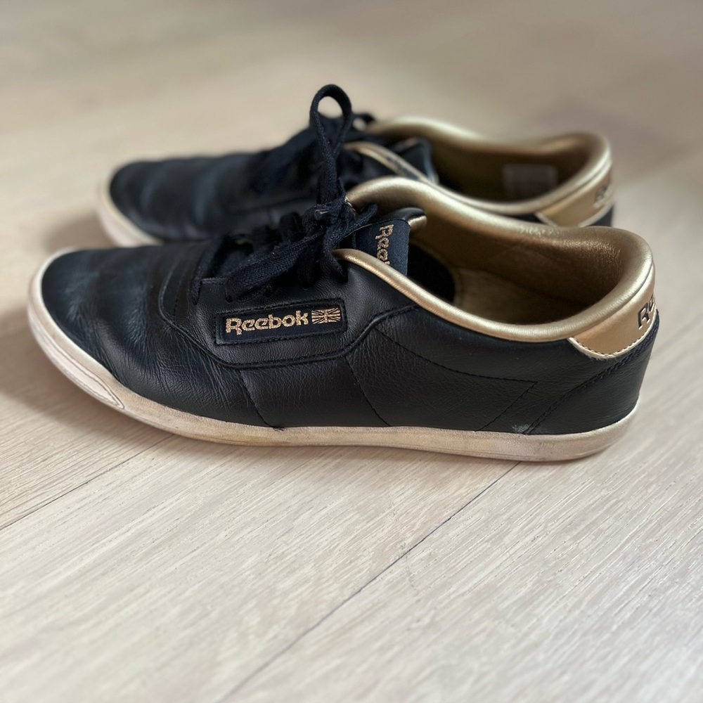 Reebok women’s black/gold leather sneakers